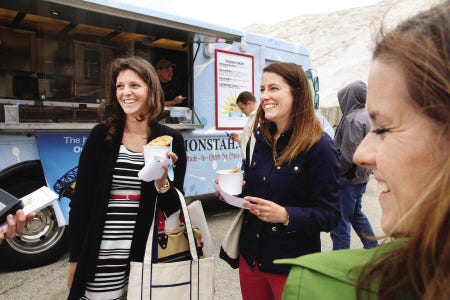 Allegiant Airlines celebrates a 15th anniversary Tuesday with a free ice cream from The Cookie Monstah truck at the Isles of Shoals Steamship Co. in Portsmouth on Tuesday. Chelsea Derry, Kristin Burke, and Elizabeth Lamport of Saltwater Integrated Creative Agency stop for some cookie sundaes.
