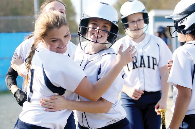 Traip Academy's Bri Lamoureux (center) celebrates with teammates, including Kendra Kagiliery (left) after crossing home plate during Thursday's game at York. Traip beat York, 8-7.