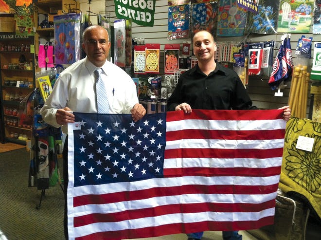 Mayor Dean Mazzarella and Joe Firmani hold up a flag, like ones to be donated to Veterans’ families.