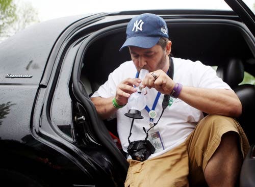 Photo by Marie Dirle/New Jersey Herald - Lefty Grimes, member of the Coalition for Medical Marijuana and cardholding patient, lights up his plastic bong in front of the Sparta municipal building in support of Scott Waselik's court hearing Friday, May 16.