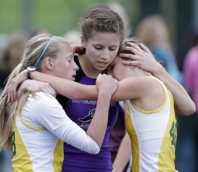 Grace Taylor of Jackson, center, embraces Hannah Werren and Hannah Thompson, both of GlenOak after the 1600 meter run during the Federal League track meet at GlenOak Friday. Taylor won the event, Werren finished second and Thompson was third.
