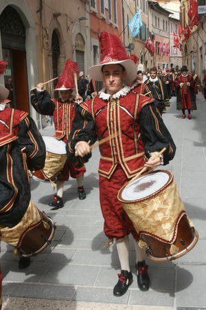 A band representing one of the Foligno, Italy, neighborhoods marches through the streets of the old city. Foligno's Quintana is a centuries-old competition that blends horsemanship with jousting skills in this city of 56,000.