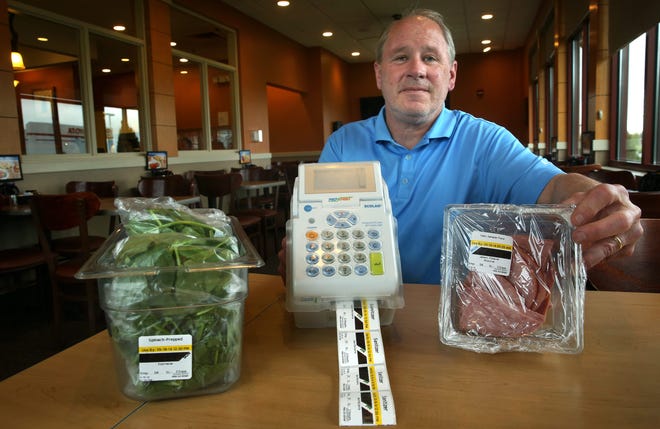 IHOP manager Don Flynn shows off a label maker used to generate labels for prepared food items served at the restaurant. Items such as spinach leaves and slices of ham have labels listing contents, preparation dates and expiration dates. Photos by David Spencer /The State Journal-Register