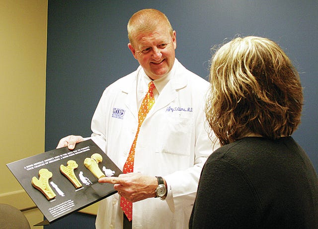 Orthopedic surgeon Dr. Jeffrey Adams discusses the signs of osteoporosis with a patient. (Courtesy photo)