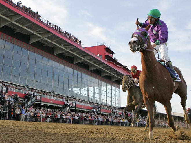 Jockey Victor Espinosa pumps his fist after crossing the finish line atop California Chrome after winning the 139th Running of the Preakness Stakes Saturday afternoon at Pimlico Race Course in Baltimore.