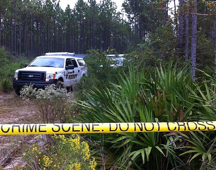 Authorities investigate the scene after Arthur Moore's body as found last year.
