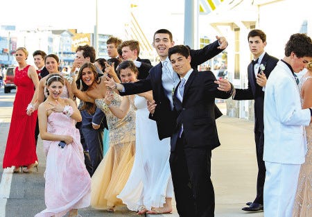 Winnacunnet High School Junior Prom attendees joke around Saturday while waiting for their limos at the Seashell Stage on Hampton Beach.