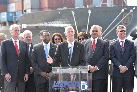 In this March 10, 2014 file photo, Florida Governor Rick Scott discusses port expansion and creation of a port task force while standing in front of the container ship Hanjin Mundra at the TraPac terminal in Jacksonville, Fla.
