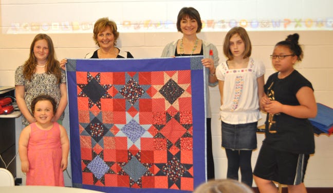 Maine first lady Ann LePage visited Wells Junior High School to receive quilts on behalf of the Travis Mills Project National Veterans Family Center in Belgrade.