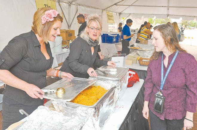 Terri Dzienis looks at empanadas, pollo Andalucia (below) and vegetarian paella from Tapas 218 during the Taste of Canton. Working the booth for Tapas 218 were Heather Janson and Gillian Kaschek
