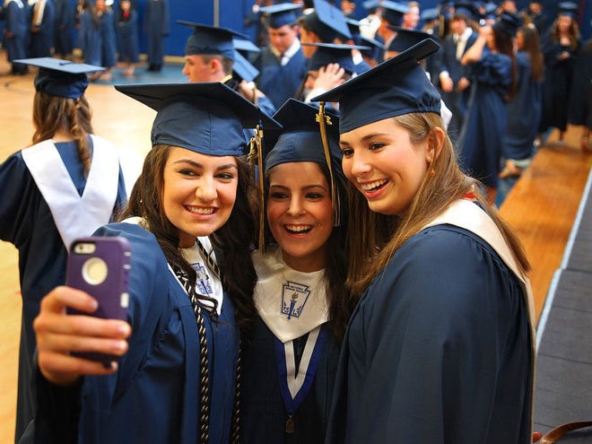 Meaghan Carnell of Weymouth, Celine El Abboud of Hanover and Olivia Conrad of Hanover capture as moment at graduation at Archbishop Williams High School in Braintree on Thursday, May 22, 2014.