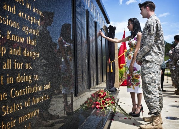 Erika Quinn finds her brother Patrick's name on the memorial wall during the Army Special Operations Command ceremony Thursday.