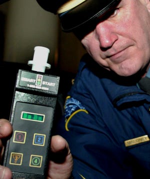Massachusetts State Police Lt. Paul Maloney holds an ignition interlock device in 2006 outside of the statehouse in Boston. Connecticut legislators unanimously passed a bill expanding a requirement that drunken driving offenders install such devices in their vehicles. The measure awaits Gov. Dannel P. Malloy’s signature.