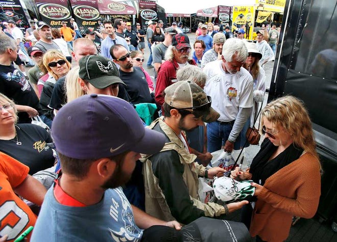 Top Fuel driver Brittany Force signs autographs for fans prior to her first run on Saturday at the 2014 NHRA Kansas Nationals.