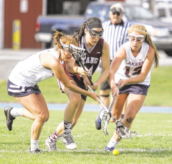 Bishop Stang's Erin Lester fights with Apponequet's Liz Loranger and Allie Noyes for the ground ball.
