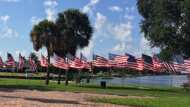 Flags fly this morning at the Forest Hill Boulevard entrance to Lake Clarke Shores.
