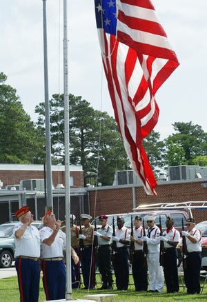 Members of the Oriental Marine Corps League Detachment raise the American flag while members of the Pamlico County Veterans Honor Guard stand at attention during Memorial Day ceremonies Monday in Bayboro.
