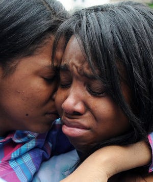 Florence Beaulieu’s oldest daughter, Emmanuella Saint-Louis, 16, right, is comforted Monday by her cousin Dianna Paul.