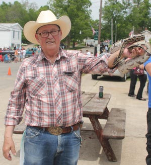 Frank DePue of Greenville, a former Hubbardston resident and owner of Animal Crackers Farm in Greenville, strolls along the Memorial Day parade route in downtown Hubbardston May 26 with pal LeRoy, a ball python.