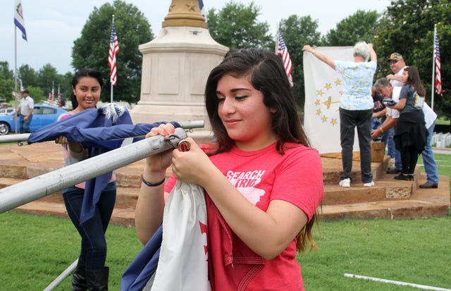 Rachel Rodemann • Times Record
Brenda Herrera, Darby Junior High School seventh-grader, removes a state flag from its pole at the U.S. National Cemetery in Fort Smith on Tuesday following its display for the Memorial Day holiday Monday.