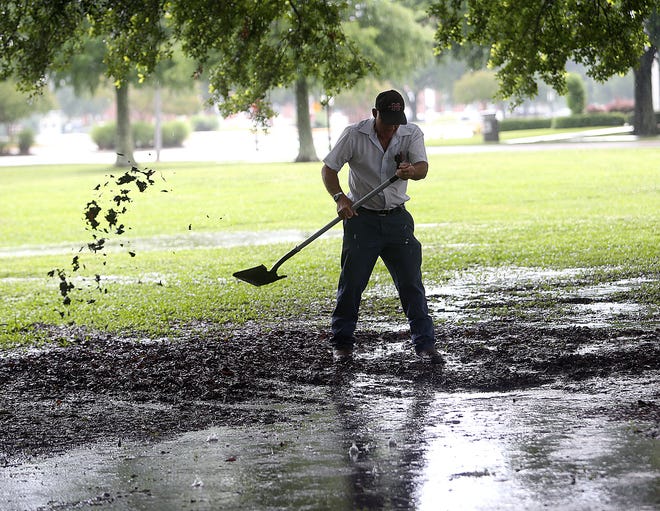 Ronald Charpentier clears a drain Friday morning on the Nicholls State University campus. Showers and thunder storms are expected to continue today in Lafourche and Terrebonne parishes.