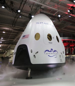 The SpaceX Dragon V2 spaceship is unveiled at its headquarters on Thursday, May 29, 2014, in Hawthorne, Calif. SpaceX, which has flown unmanned cargo capsules to the International Space Station, unveiled the new spacecraft Thursday designed to ferry astronauts to low-Earth orbit.