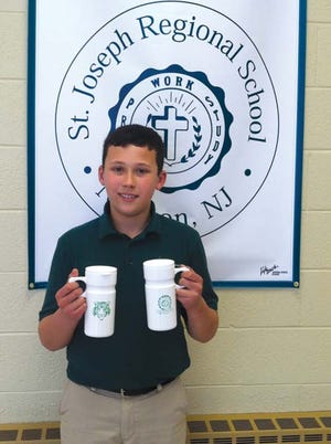 Luke Dykstra is shown displaying his TREPS project. Dykstra produced a thermal drink mug that is totally made in the USA and features the school logo.