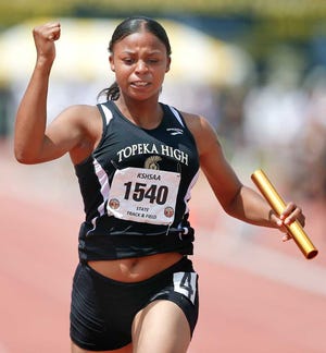 Topeka High's Latiyera Yeargin pumps her fist in victory after crossing the finish line to give her and the Trojan 400-meter relay team first place Saturday afternoon in the 2014 Track and Field State Championships at Cessna Stadium in Wichita.