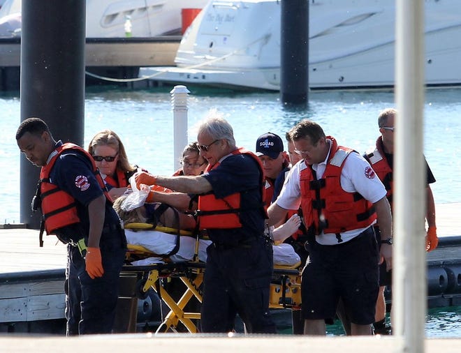 A woman is rescued from the South Side stretch of Lake Michigan, Sunday, June 1, 2014, after a boat she was in capsized Saturday night miles from Chicago's shoreline. The U.S. Coast Guard said crews are searching for as many as four other people. (AP Photo/Sun-Times Media, Alex Wroblewski)