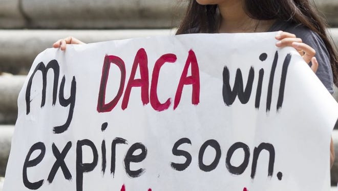 Juana Guzmán, a University of Texas senior from Fort Worth, holds a sign at a news conference Monday that urged immigrants to renew their status under the Deferred Action for Childhood Arrivals program.