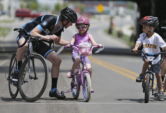 Andrew Eastman gives Lola Mikesell a pep talk before the kids' 10-and-under race on Rich Street. The 0.8-mile course gave kids a chance to participate in the bike rally yesterday.