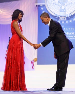 President Barack Obama bows as he and first lady Michelle Obama, wearing a ruby-colored chiffon and velvet Jason Wu gown, get ready to dance on Jan. 21, 2013, at the Inaugural Ball at the Washington Convention Center during the 57th Presidential Inauguration in Washington.