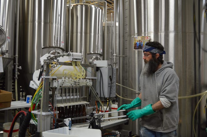 Jason Nelson, one of the brewers and quality-control inspectors at Saugatuck Brewing Co., prepares to bottle the latest batch of beer. Brian VanOchten/Sentinel staff