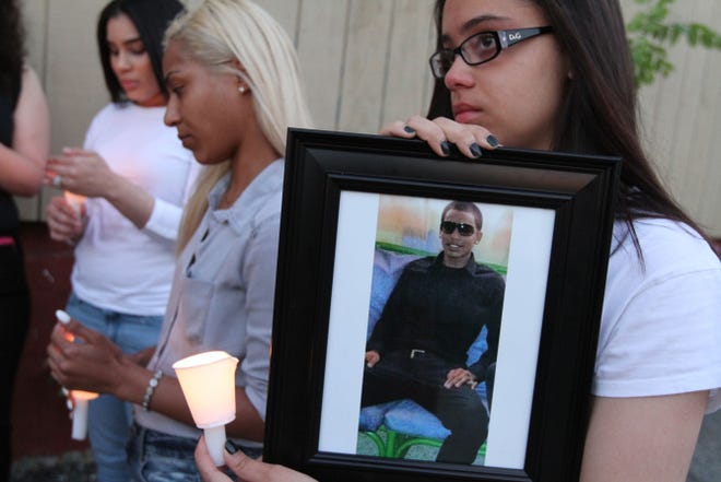 Roseemily Nunuz, 22, holds a photo of her late boyfriend, Francis M. Rodriguez, during a candlelight vigil Monday evening at Warrington Street and Elmwood Avenue, in Providence, where Rodriguez was shot and killed on May 2. Family members say they will hold a vigil there on the second of every month until justice is done. They say the authorities have a suspect but no arrest has been made.