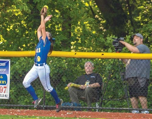 Photo by Warren Westura/New Jersey Herald — Lyndhurst center fielder Dina Ingenito has the fly ball from High Point’s Ally Curry bounce off her outstretched glove and against the lens of a videographer, then down onto the field for a home run.