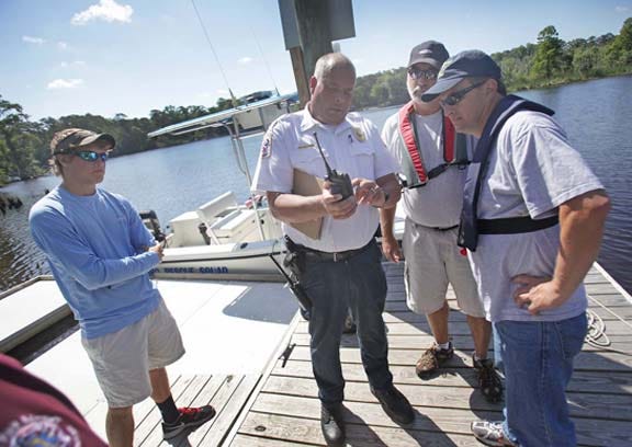 Ira Whitford, center, assistant director of Craven County Emergency Services, goes over some last-minute details with Vanceboro's Van Voorhees and Keith Morris before they leave to patrol the Trent River in River Bend Tuesday morning. Kortlyn Templin, left, a friend of the missing teenager, waits for information.