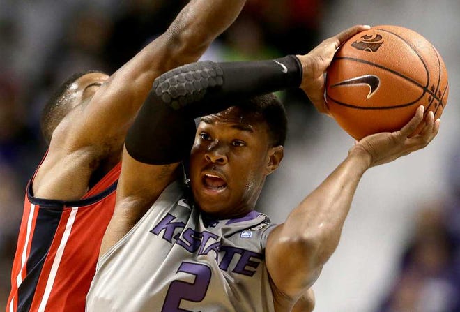 Kansas State's Marcus Foster (2) looks for a teammate to pass to as he is pressured by Mississippi's Martavious Newby during the first half of an NCAA college basketball game Thursday, Dec. 5, 2013 in Manhattan, Kan.