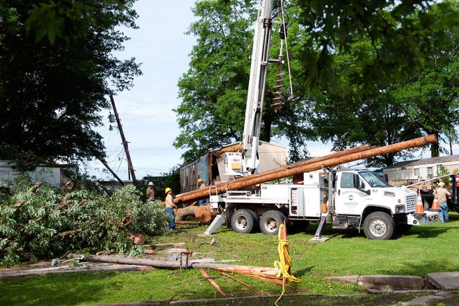 A crew Wednesday morning replaces a utility pole that was damaged after a tree fell on a mobile home Tuesday night at 4150 Lenoir St. An early-morning storm downed trees and dumped heavy rain and hail throughout the county. Many were left without electricity in Columbia and Boone County.