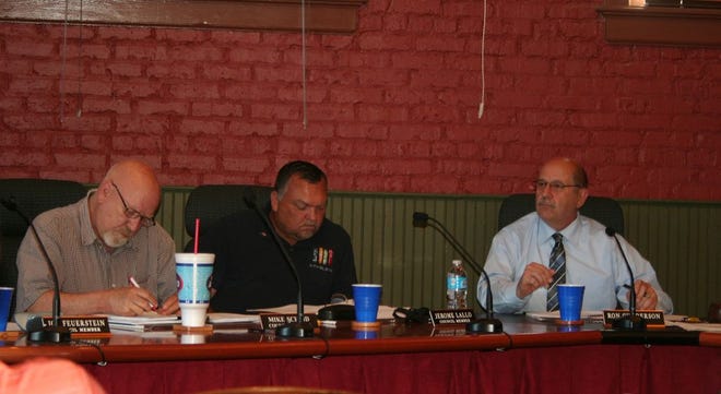 Belding City Council members Mike Scheid, left, and Jerome Lallo, alongside city of Belding Mayor Ron Gunderson, right, listen to public comments during Tuesday evening’s Belding City Council meeting.