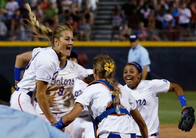 Florida pitcher Hannah Rogers, left, celebrates with teammates Aubree Munro (1) and Kelsey Stewart, right, following an NCAA Women's College World Series softball tournament game in Oklahoma City, Tuesday, June 3, 2014. Florida defeated Alabama 6-3 and won the title.