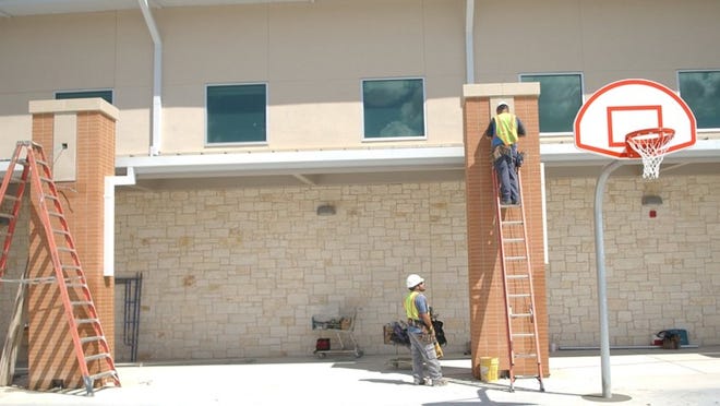 Construction workers complete their work on the West Cypress Hills Elementary School courtyard May 28.