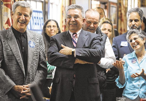 District Attorney Michael O'Keefe smiles as Barnstable County James Cummings speaks during O'Keefe's campaign announcement. Bruins hockey great Bobby Orr is at left.
