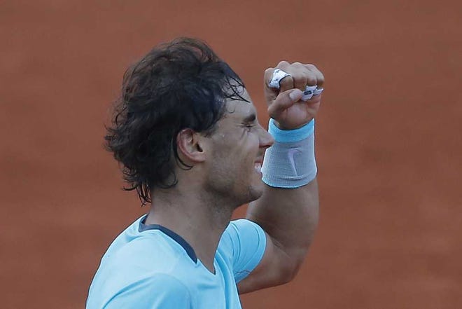 Spain's Rafael Nadal celebrates winning his quarterfinal match of the French Open tennis tournament against compatriot David Ferrer at the Roland Garros stadium, in Paris, France, Wednesday, June 4, 2014. Nadal won in four sets 4-6, 6-4, 6-0, 6-1. (AP Photo/Michel Spingler)