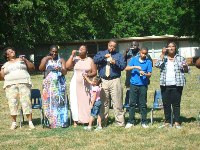 Members of Karma Hopper's family blow bubbles at the ceremony to dedicate the playground in Karma's memory. In the center are her parents, Gerald and Terinda Hopper, and sister, Gwen, a first-grader at Graham Elementary.
Photo submitted by Amber Cox