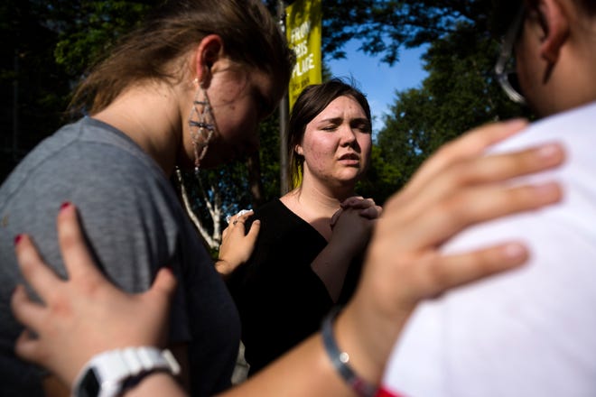 Following the lift of a lockdown in the wake of a school shooting, Seattle Pacific University students pray together Thursday on the campus of Seattle Pacific University in Seattle, Wash. A gunman fatally wounded one young man and seriously injured a 20-year-old woman before being disarmed by a student worker at the small college. (AP Photo/seattlepi.com, Jordan Stead)