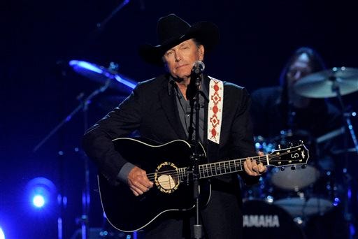 FILE - This April 7, 2013 file photo shows George Strait performing at the 48th Annual Academy of Country Music Awards at the MGM Grand Garden Arena in Las Vegas. It's the end of the trail for country music king George Strait, who will wrap up his final tour Saturday, June 7, 2014with a star-filled show at the lavish home of the Dallas Cowboys in his home state of Texas. The show brings an end to nearly 40 years on the road for Strait, which started in 1975 with the Ace in the Hole Band. He's had more songs top Billboard's country music charts than any other musician. And while he's quitting the road he may yet add to his total after renewing his deal with MCA Records last year to produce five more albums. (Photo by Chris Pizzello/Invision/AP, File)