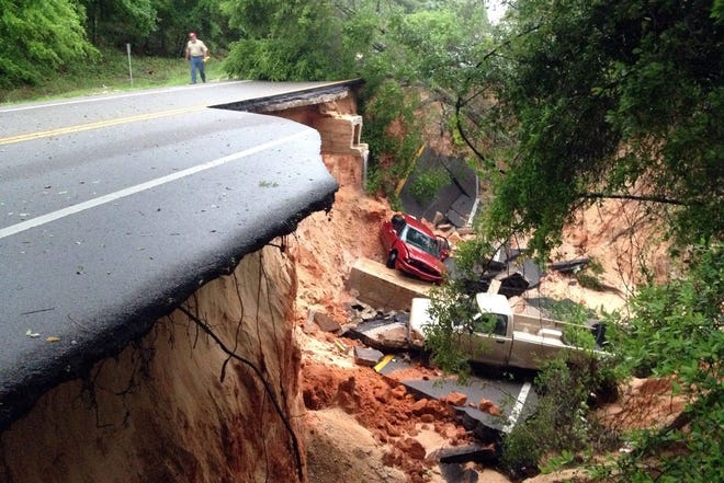 This April 30, 2014 file photo shows a man walking near a portion of the Scenic Highway collapsed near Pensacola, Fla. While other coastal states take aggressive measures to battle the effects of global warming, Florida's top politicians are challenging the science and debating whether the problem even exists. Those positions could impact the political fortunes of the state's chief skeptics, including Sen. Marco Rubio and former Gov. Jeb Bush, both of whom are weighing presidential campaigns in 2016. (KATIE E. KING | AP File Photo/Pensacola News Journal,)