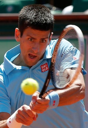 Novak Djokovic hits a return shot to Ernests Gulbis during their semifinal match at the French Open on Friday.