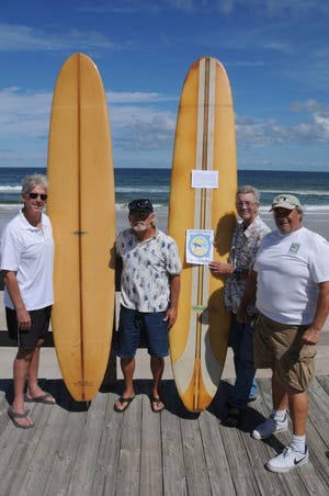 Bud Wright, Ron Dreggors, Mike Martin and Joel Paige pose with two 1960s longboards at Bethune Beach Park. They are preparing to open the New Smyrna Beach Museum of East Coast Surfing on Canal Street.
