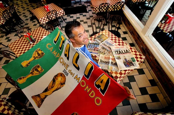 Gianni Schiano, owner of the downtown Palace Pizza, displays his 2006 World Cup championship flag that was made in honor of Italy winning its fourth World Cup at his restaurant in Lakeland on Thursday.